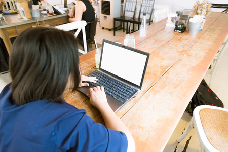 Happy Young Beautiful Asian Woman Using Laptop in art cafe, Indoorsの写真素材