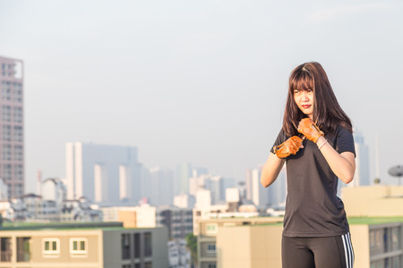 Asian female in sports clothing make body stretching before workout on building background.のeditorial素材