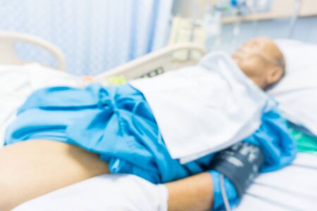 Old man sickness sleep on the bed in hospital blurred bokeh health conceptの写真素材