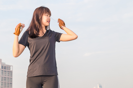 Asian woman fitness sunrise stretch before jogging workout wellness concept building background.のeditorial素材