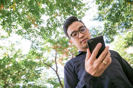 Business man talking on cellphone in green park, Business communication conceptのeditorial素材