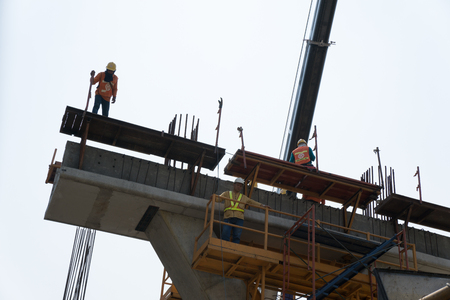 Silhouette engineer standing orders for sky train construction, Heavy industry at work concept.