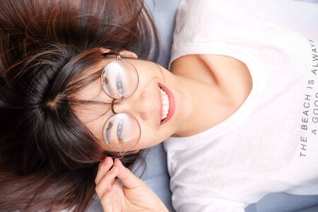 Glasses smile asian women rest on sofa, Beautiful women smilling