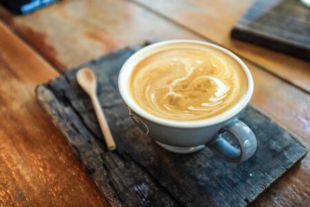 Latte art coffee on wood table with textureの写真素材