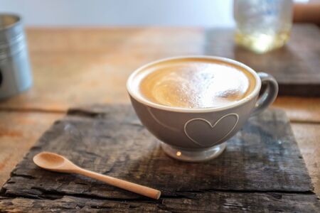 Latte art coffee on wood table with textureの写真素材