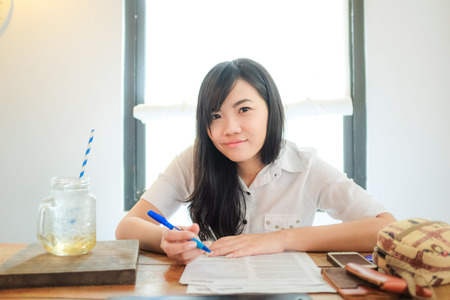 Asian women hold pen for write a business plane in cafe