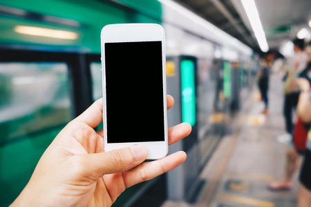 Smartphone black screen in hand at train station blurred people