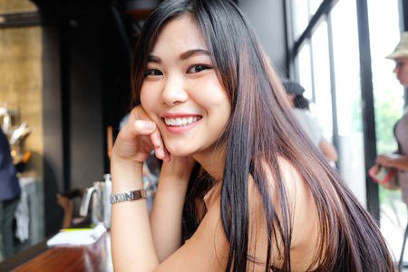 Portrait of smiling asian women sitting in loft cafe, Business fashion womenの写真素材
