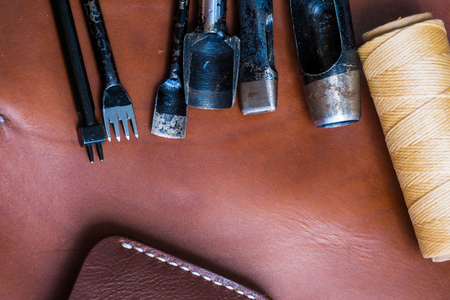 DIY leather bifold wallet with crafts tool object on brown leather backgroundの写真素材