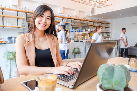 Smiling business women wear casual suit using laptop for business communication in modern loft cafeの写真素材