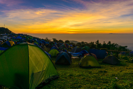 Camping tent on the hill sunrise time colourful sky with group of touristのeditorial素材