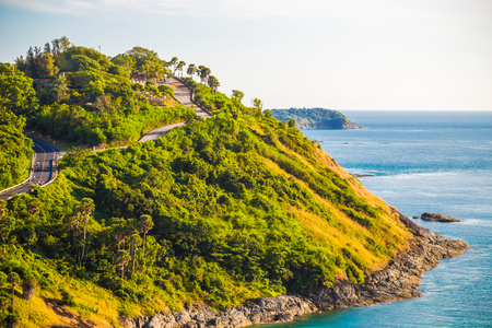 Beautiful stone rocky sea beach with yellow grass at Phuket island, Thailandの写真素材