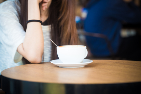 Women pouring with latte coffee on wood table hand close upの写真素材
