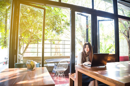Asian business women use laptop computer for internet search engine in coffee shopの写真素材