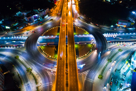 Roundabout intersection city road at night with vehicle light movement aerial viewのeditorial素材