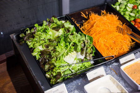 Colourful vegetable fresh salad with sauces on salad barの写真素材