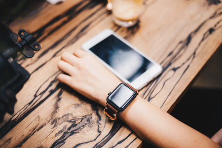 Women using smart watch in cafe wood bar close up on handの写真素材