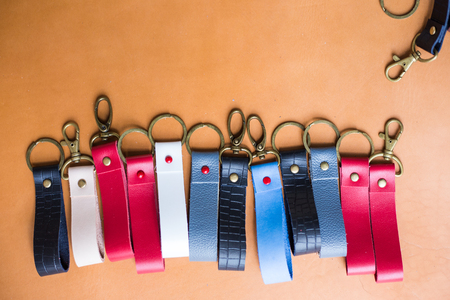 Genuine leather color keychain with metal head on leather backgroundの写真素材