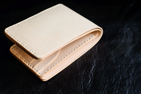 Vegetable tanned leather wallet on black leather background, Craftsmanship objectの写真素材