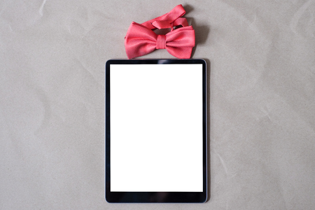 Bowtie with tablet screen on brown paper gift for you conceptの写真素材