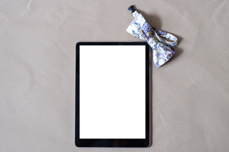 Bowtie with tablet screen on brown paper gift for you conceptの写真素材