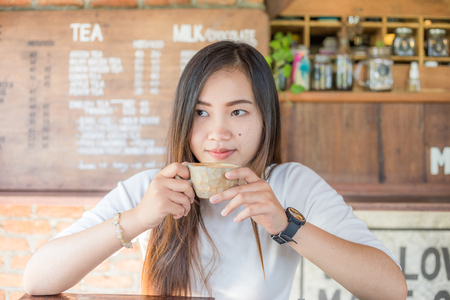 Young pretty women with cup of latte coffee in vintage cafe, Food and drink conceptの写真素材