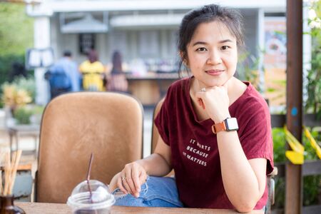 Portrait of young asian business women with smart watch and cellphone sitting in corporateの写真素材