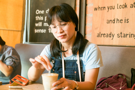 Asian business women drinking latte coffee in vintage cafe, Food and drinkの写真素材