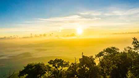 Sunrise scenic with colorful majestic sky and fog on peak of mountain nature vacationの写真素材