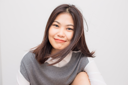 Cheerful asian young smiling to camera on white backgroundの写真素材