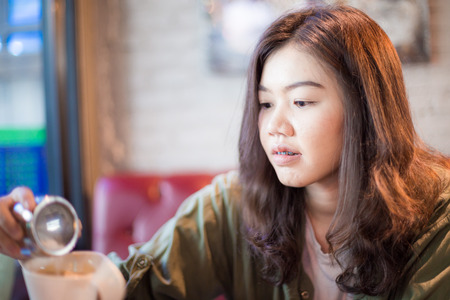 Fashion asian women drinking latte coffee in art cafe, Business womenの写真素材
