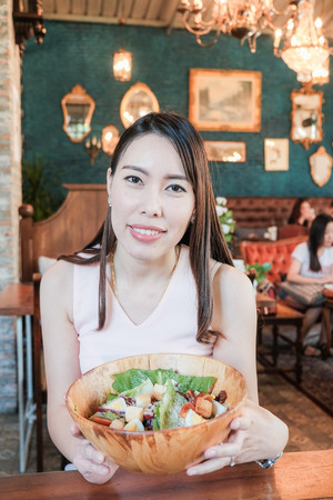 Portrait of wellness healthy women with slad bowl in cafe, Healthy foodの写真素材