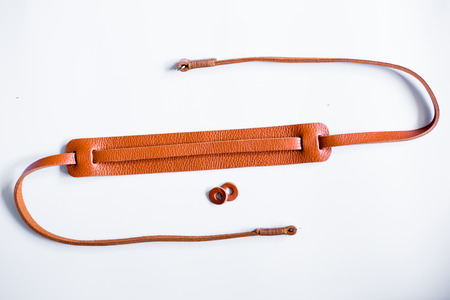 Leather mirrorless camera strap with thread handmade work on white backgroundの写真素材