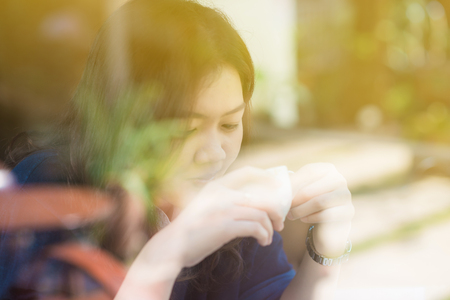 Young business asian woman hold white coffee cup in modern cafe drinking latte coffeeの写真素材