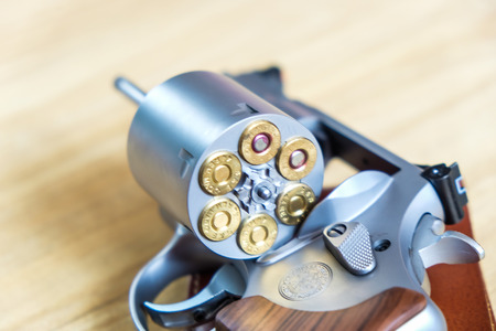 .357 .44 magnum revolver gun with bullet on wood background ammo objectの写真素材