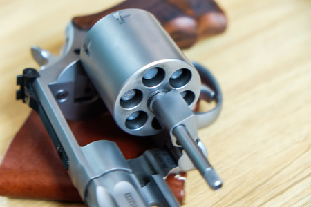 .357 .44 magnum revolver gun with bullet on wood background ammo objectの写真素材