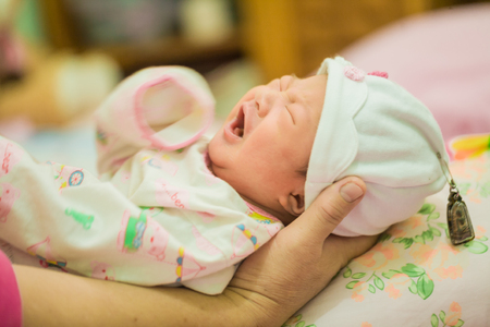 Infant asian baby girl sleeping on cozy bedの写真素材