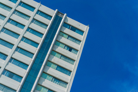 High rise skyscraper modern building against blue sky background looking from below