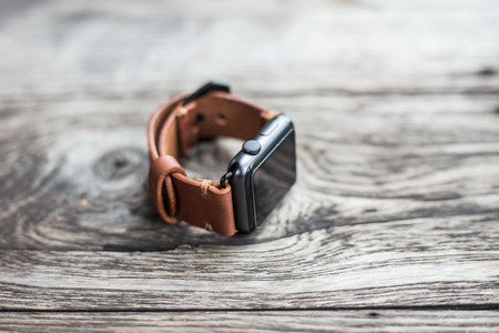 Handmade brown leather vintage watch strap craftsmanship on wood backgroundの写真素材