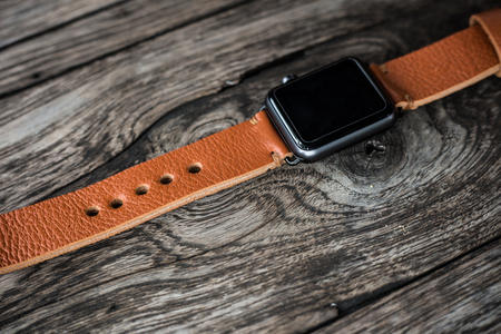 Handmade brown leather vintage watch strap craftsmanship on wood backgroundの写真素材
