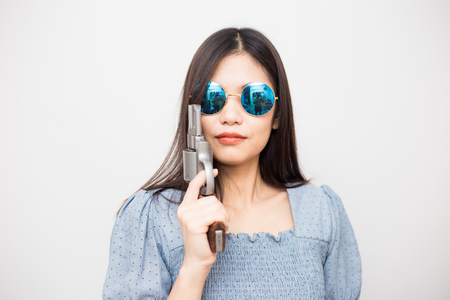 Smart asian women pointing revolver gun to audience, Crime conceptの写真素材