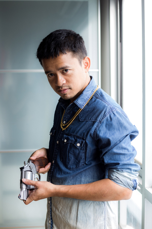 Mafia rich man in jean shirt with gold holding gun, Violence conceptの写真素材