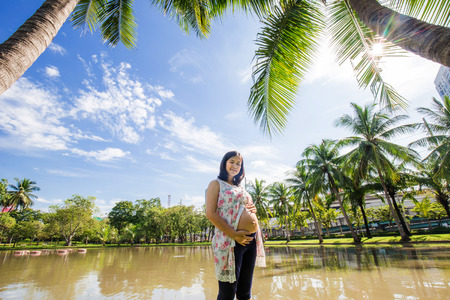 Pregnant beautiful women recreation in city public park under treeの写真素材