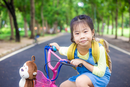 Cute asian girl having fun outdoor ride bicycle in park, Hobby of childの写真素材