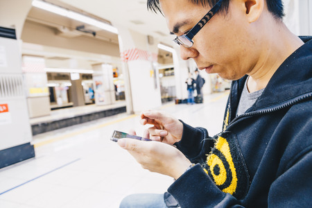 Business tourist man using smartphone in subway station, Technology conceptの写真素材