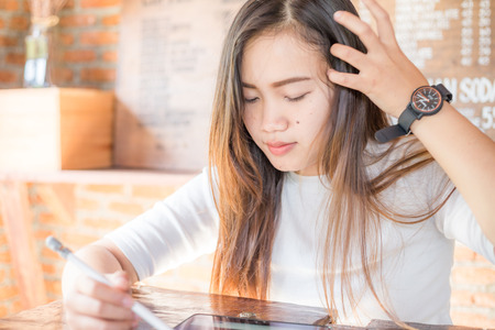 Beautiful women using tablet while sitting on wood table in art cafeの写真素材