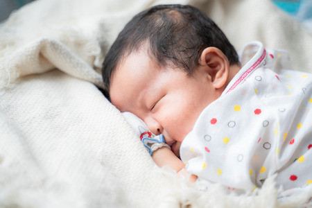 Adorable infant kid sleeping on blanket, One month babyの写真素材