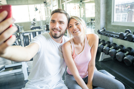 Caucasian sport couple take selfies photo after work out in gym, Couple in gymの写真素材