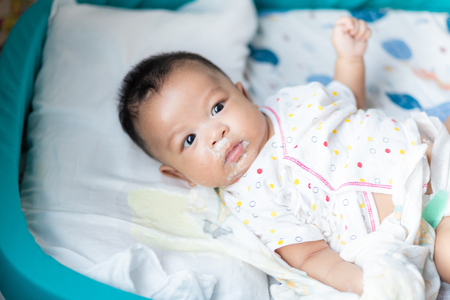 Infant baby boy vomit after eat milk on bed, Baby puke milkの写真素材
