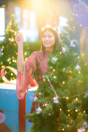 Beautiful asian christmas costume women with pine tree at nightの写真素材